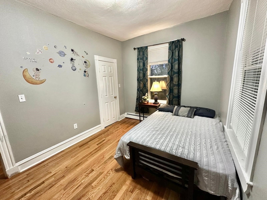 139 Park Street, Unit 4 Chelsea, MA 02150 - Photo 10 of 11 a bedroom with a bed and wooden floor