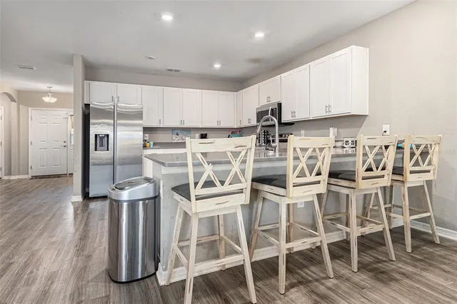 a view of a dining room with furniture a kitchen and wooden floor