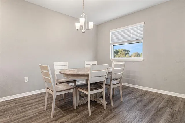 a view of a dining room with furniture a chandelier and wooden floor
