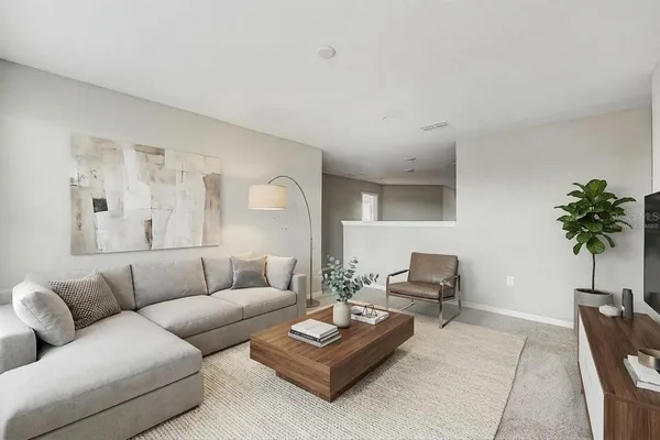 a living room with furniture and a potted plant