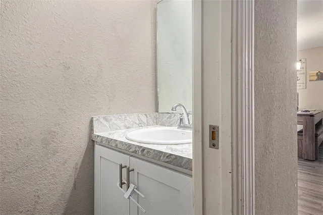 a bathroom with a granite countertop sink and a mirror