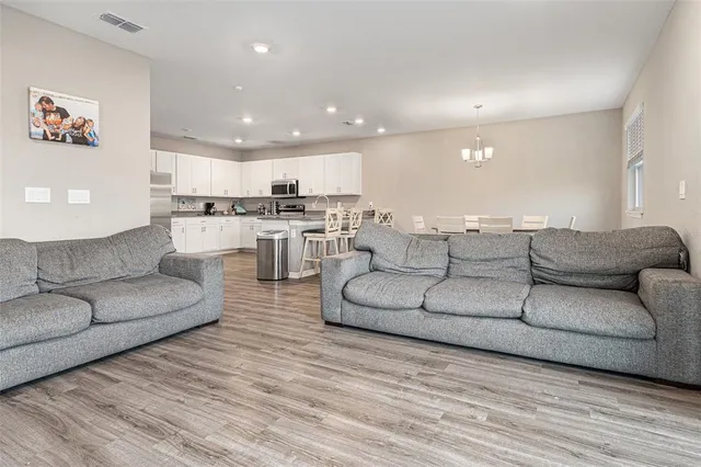 a living room with couches and a view of kitchen