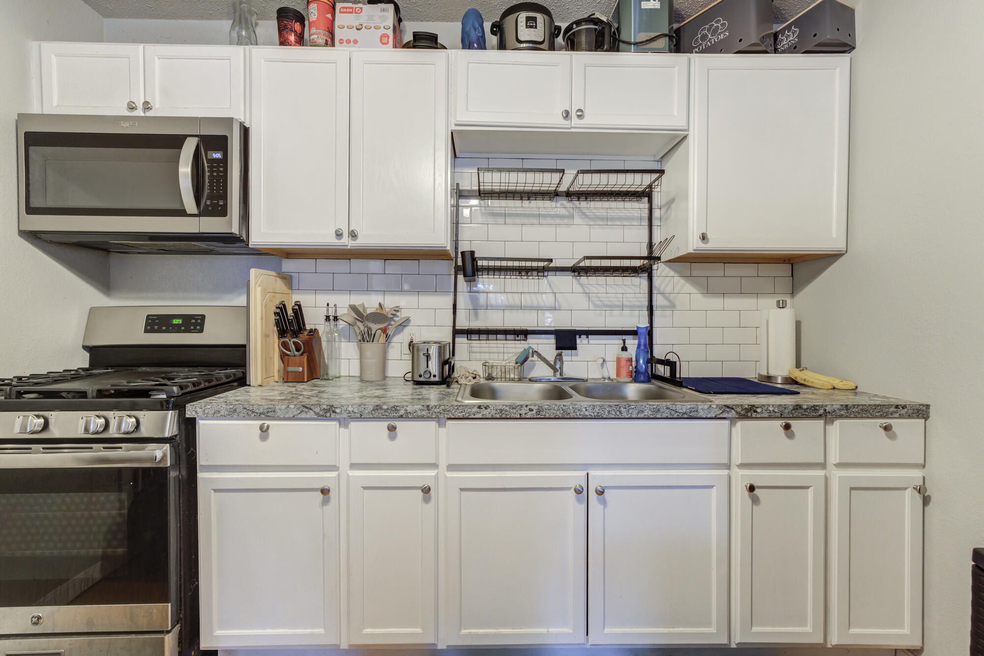 2601 25th Street Lubbock, TX 79410 - Photo 16 of 30 a kitchen with granite countertop white cabinets and appliances