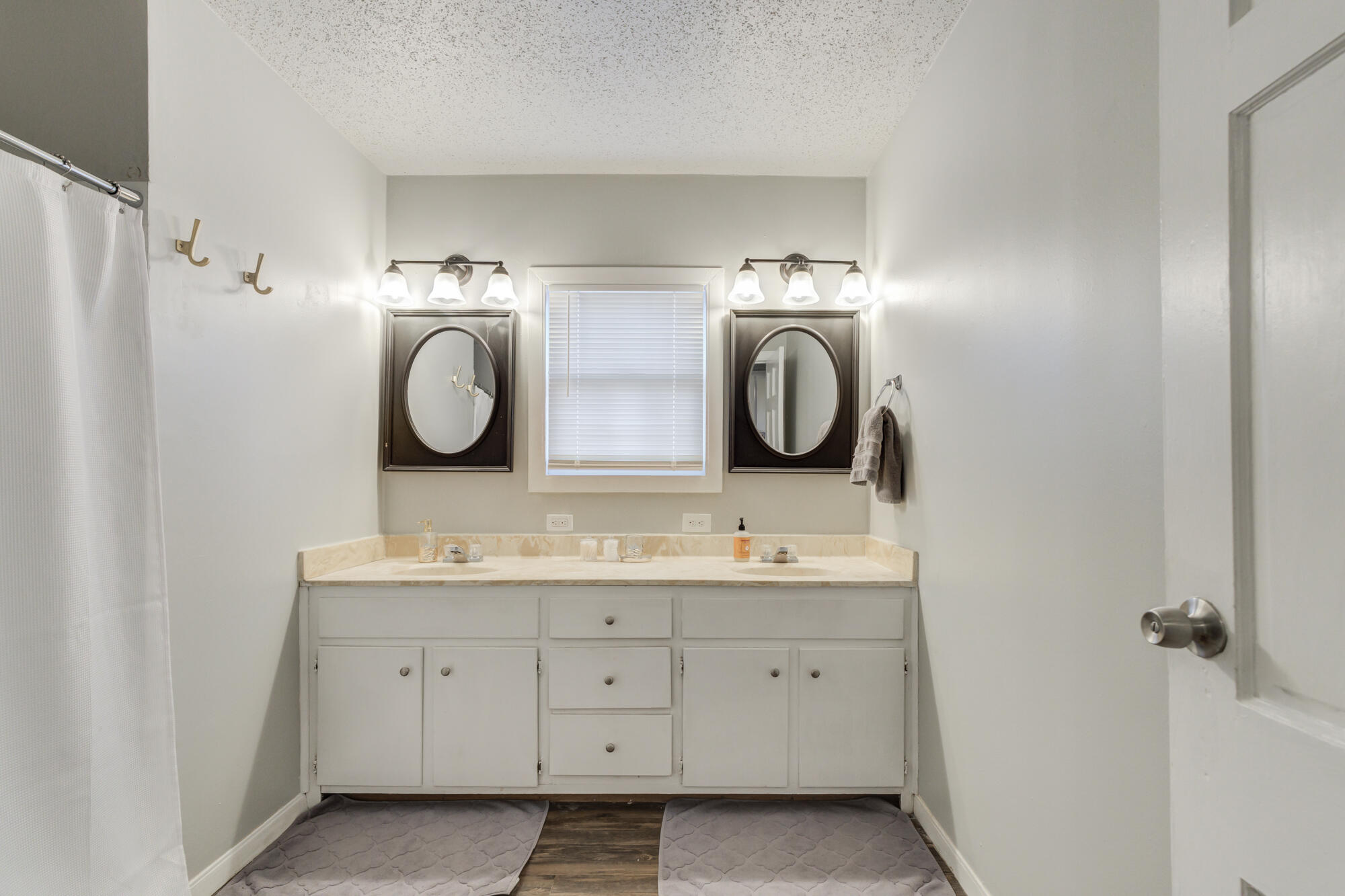 2601 25th Street Lubbock, TX 79410 - Photo 24 of 30 a bathroom with a double vanity sink and mirror with shower