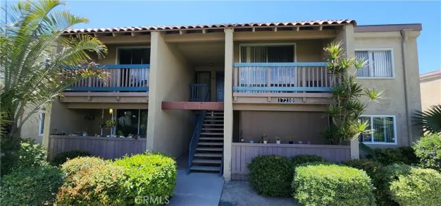 a front view of a house with lots of flowers