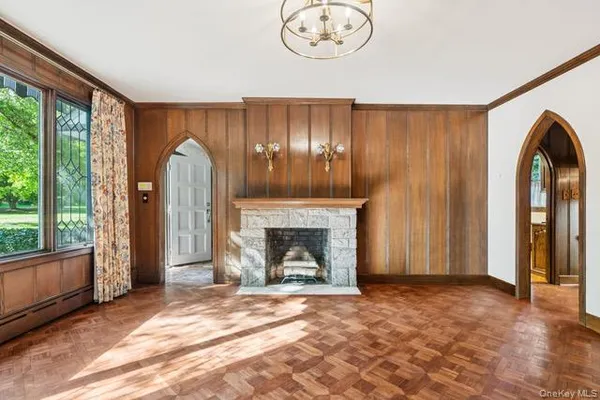 wooden floor fireplace and windows in an empty room