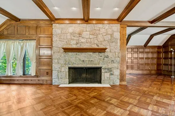 a view of an empty room with a fireplace and a window
