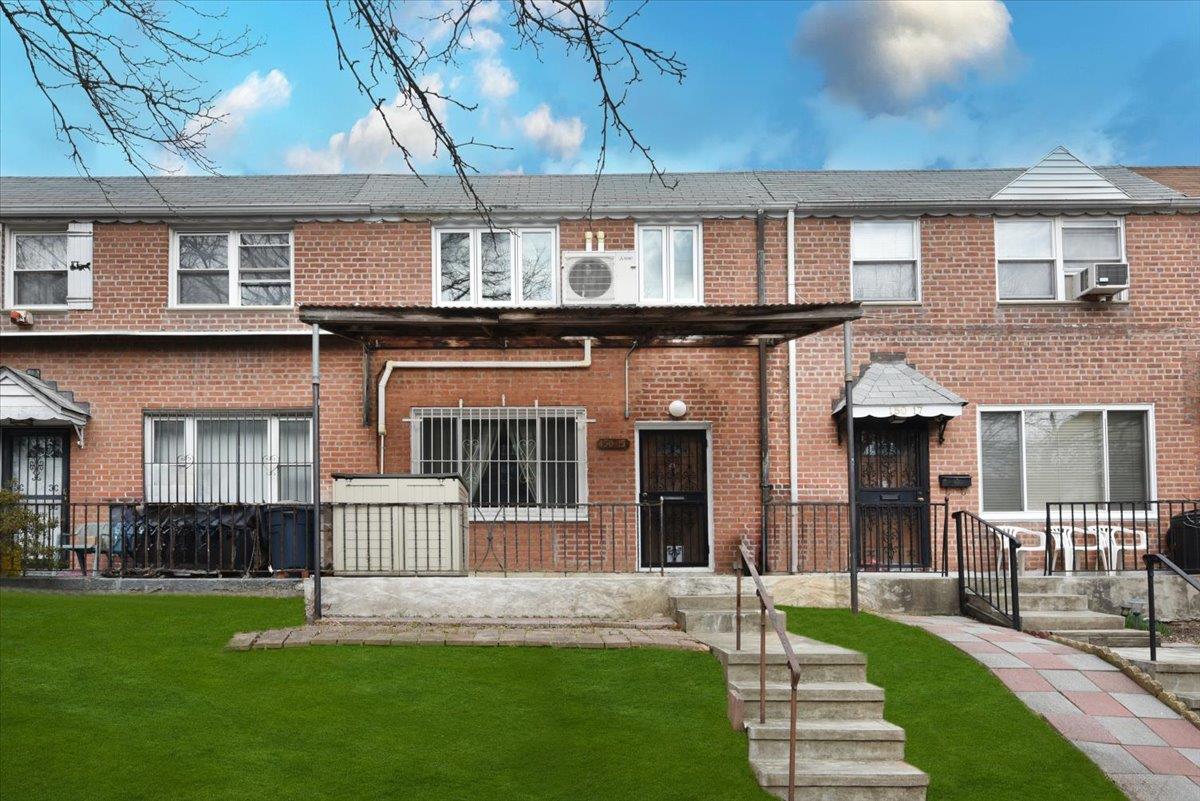 View of front facade with brick siding and a front yard