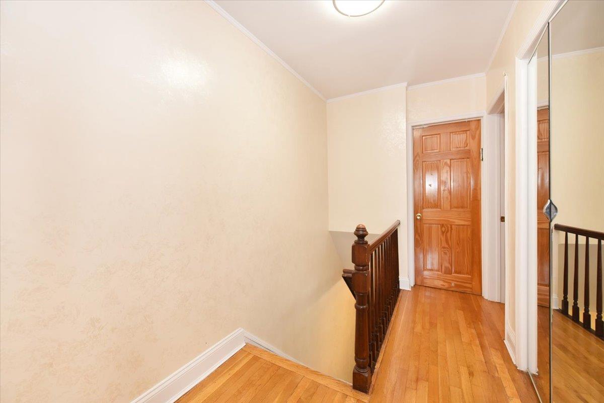 150-15 78th Road Queens, NY 11367 - Photo 14 of 28 Hallway with baseboards, an upstairs landing, light wood-style flooring, and crown molding