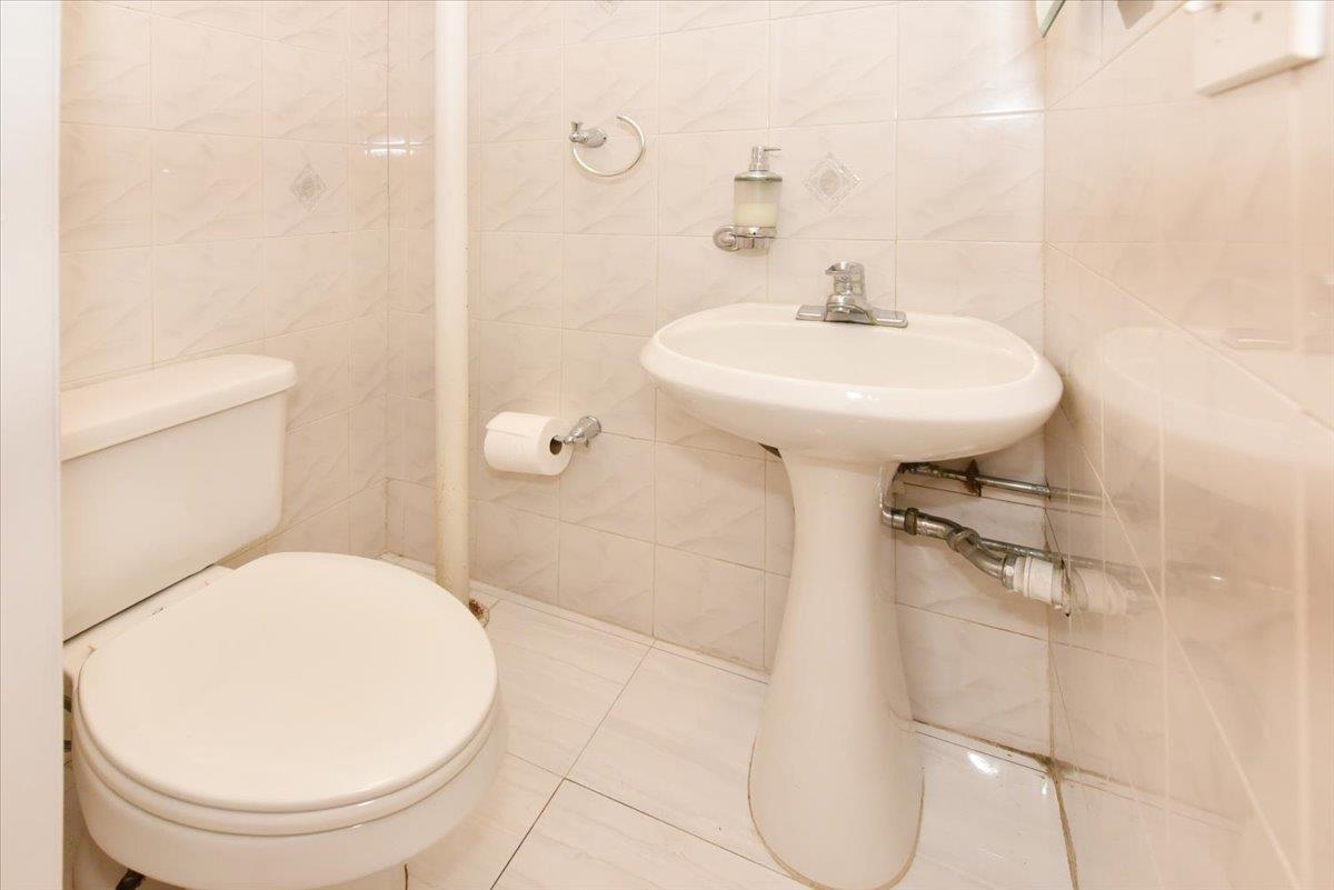 150-15 78th Road Queens, NY 11367 - Photo 25 of 28 Bathroom with tile walls, toilet, and tile patterned floors