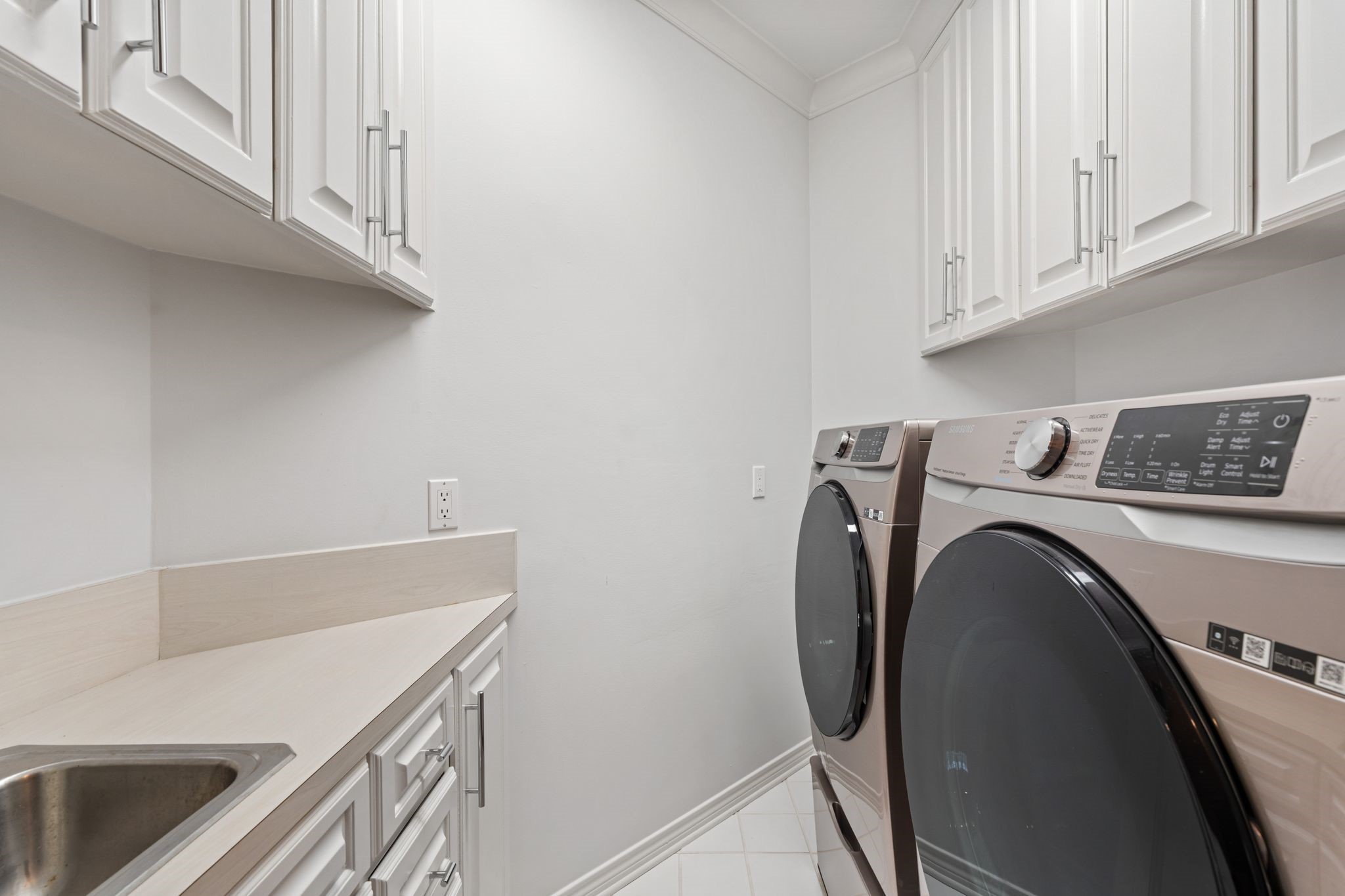201 Vanderpool Lane, Unit 137 Houston, TX 77024 - Photo 30 of 42 Conveniently located on the 2nd floor between the primary suite and secondary bedrooms, the utility room is thoughtfully designed for everyday ease. Features include washer/dryer hookups, upper and lower built-in cabinetry, countertop space for folding, a utility sink, tile flooring, and clean neutral finishes throughout.