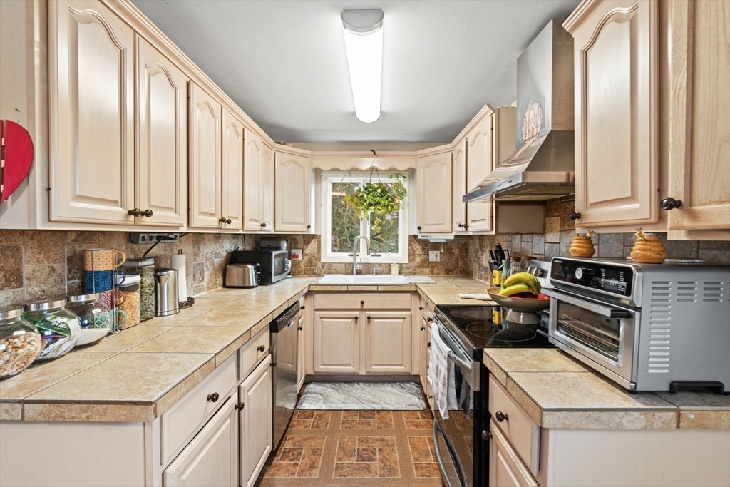 48 Tapped Street Everett, MA 02149 - Photo 12 of 24 a kitchen with a sink stove top oven and cabinets
