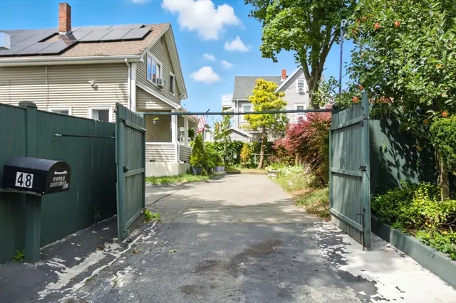 a view of a street with plants and a building
