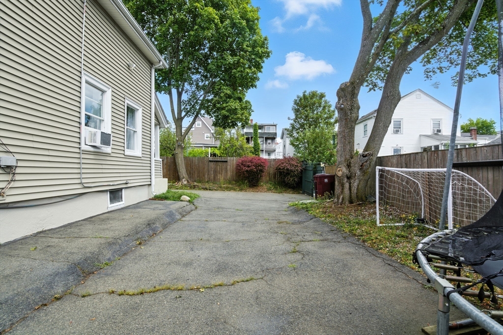 48 Tapped Street Everett, MA 02149 - Photo 22 of 24 a backyard of a house with barbeque oven and trees
