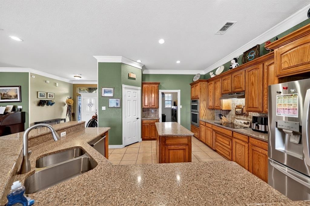 1035 Highland Road Cleburne, TX 76033 - Photo 6 of 36 a large white kitchen with stainless steel appliances granite countertop a sink and cabinets