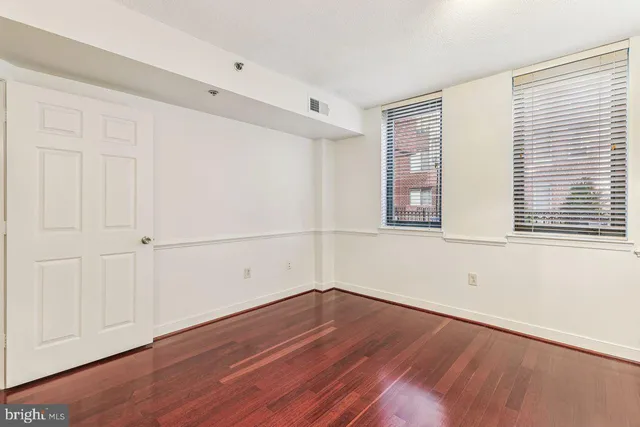 a view of a room with wooden floor and white walls