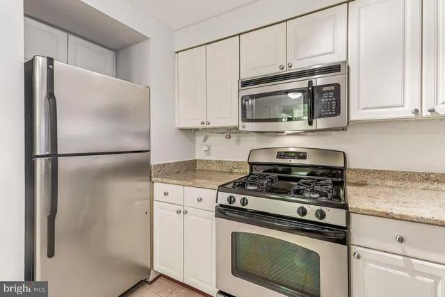 a kitchen with stainless steel appliances granite countertop a refrigerator stove and microwave