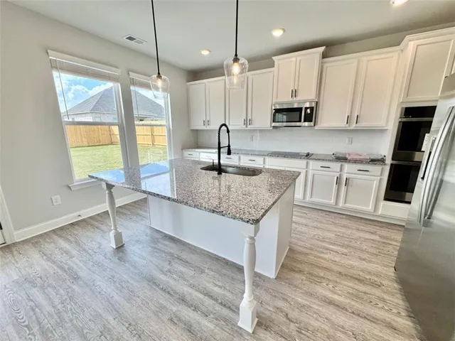 a kitchen with granite countertop kitchen island wooden floors granite counter tops and white appliances