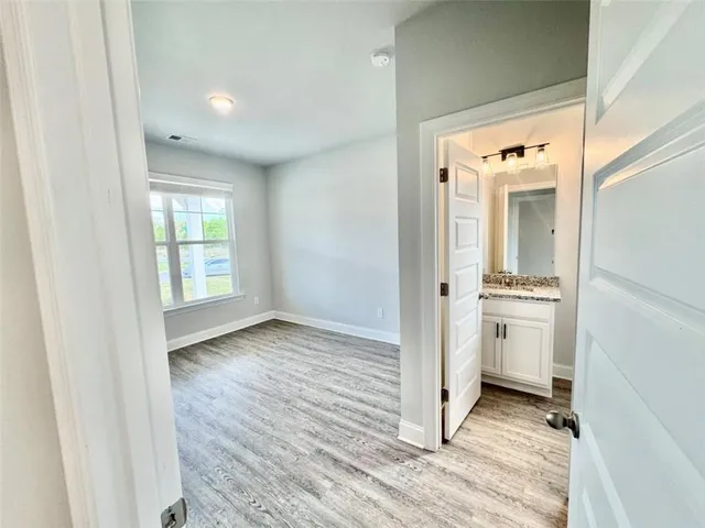 a view of a hallway with a kitchen and wooden floor