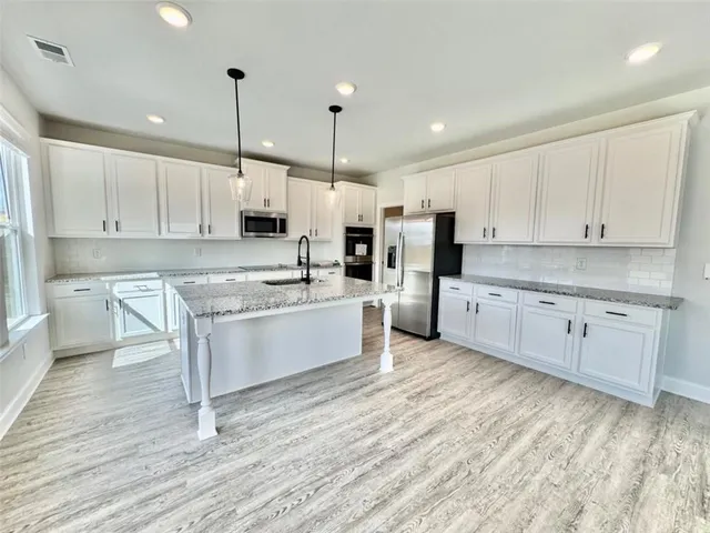 a kitchen with white cabinets and white appliances