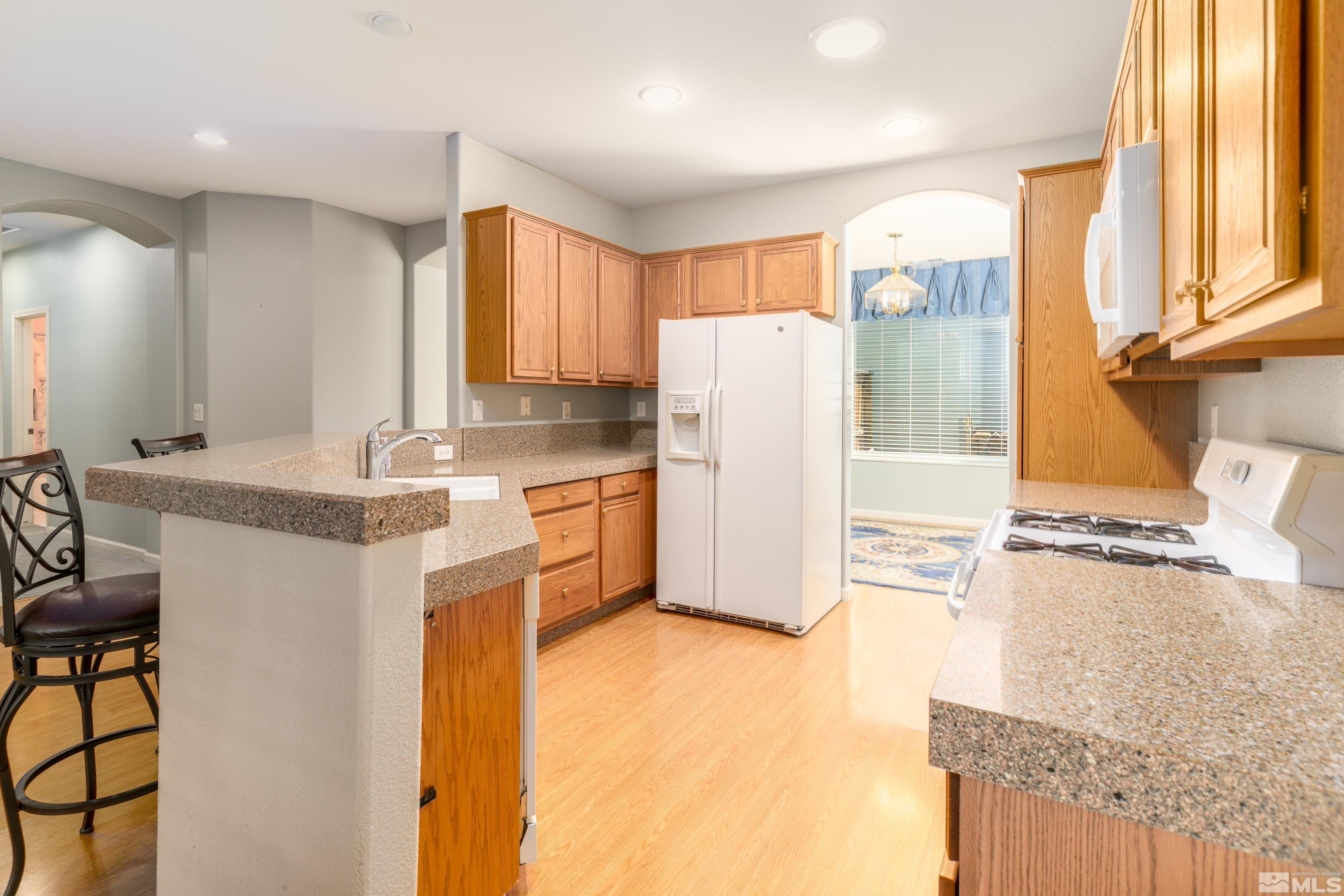 10412 Rockport Lane Reno, NV 89521 - Photo 4 of 15 a kitchen with a refrigerator a sink and cabinets