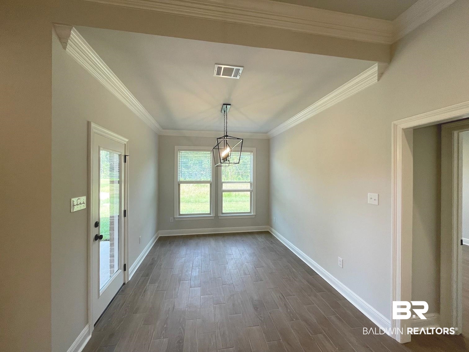 1424 Fenton Circle Foley, AL 36535 - Photo 7 of 20 Empty room featuring a notable chandelier, dark hardwood / wood-style flooring, and ornamental molding