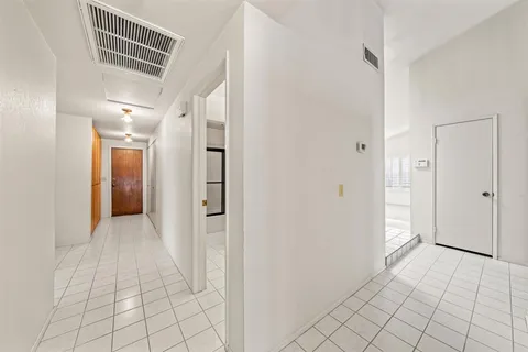 a view of a hallway with closet and bathroom