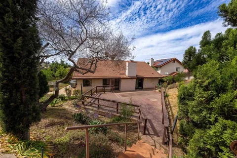 a view of a house with large trees