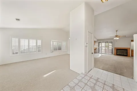 a view of an empty room with a fireplace and a window