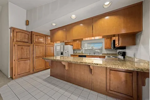 a kitchen with stainless steel appliances granite countertop a sink a stove counter space and cabinets