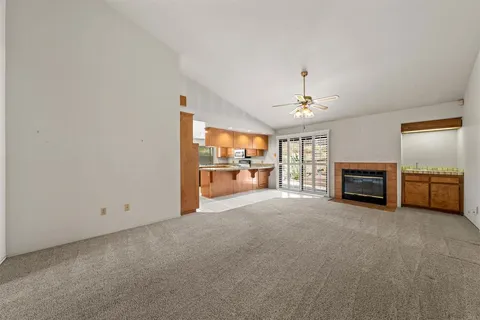 a view of an empty room with a fireplace and a window
