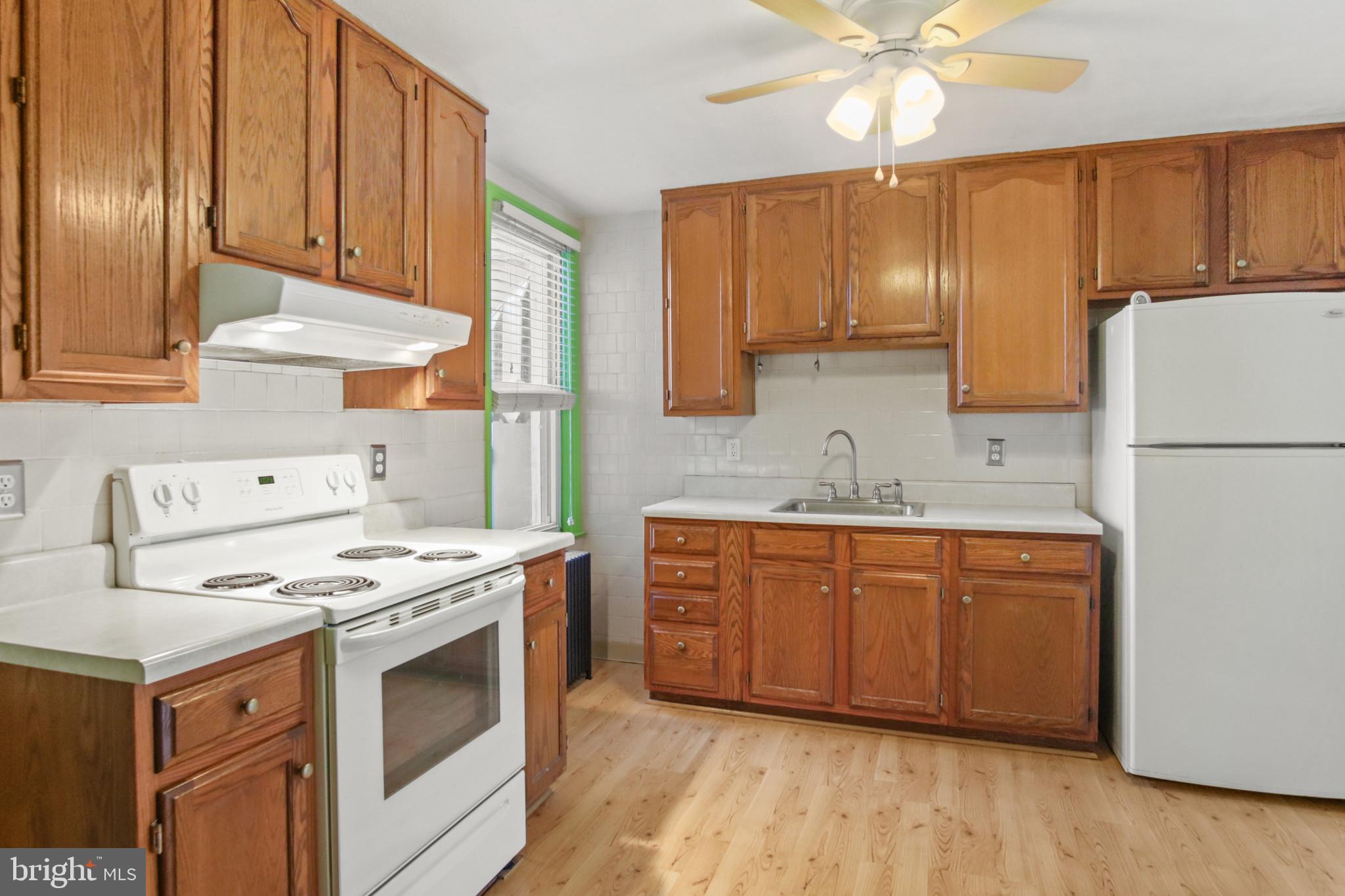 102 Willow Spring Road Baltimore, MD 21222 - Photo 10 of 28 a kitchen with stainless steel appliances granite countertop a stove a sink dishwasher and a refrigerator with wooden cabinets