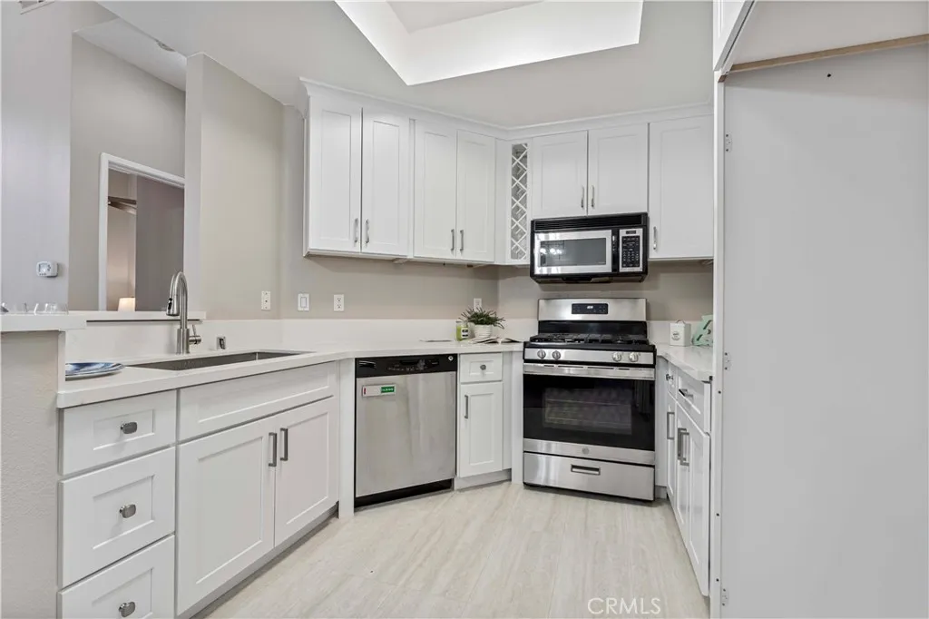 19431 Rue De Valore Lake Forest, CA 92610 - Photo 6 of 12 a kitchen with granite countertop white cabinets and stainless steel appliances