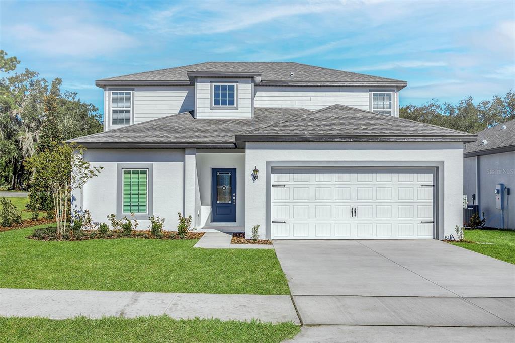 a front view of a house with a yard and garage