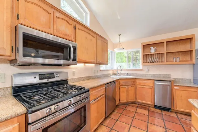 a large kitchen with a large counter space appliances and cabinets
