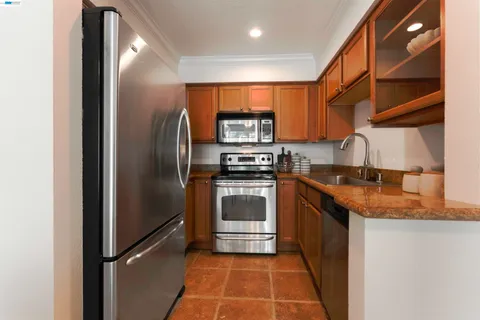 a kitchen with stainless steel appliances granite countertop a refrigerator and a stove