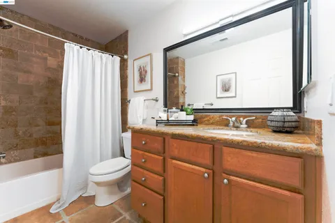 a bathroom with a granite countertop sink toilet and shower