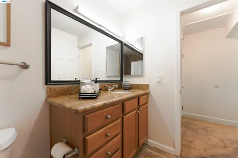 a bathroom with a granite countertop sink and a mirror