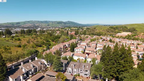 an aerial view of residential houses with outdoor space and trees