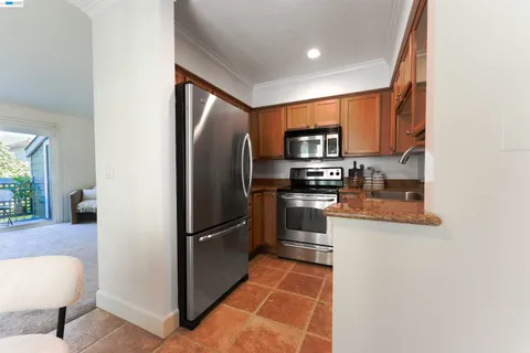 a kitchen with stainless steel appliances granite countertop a refrigerator and a stove