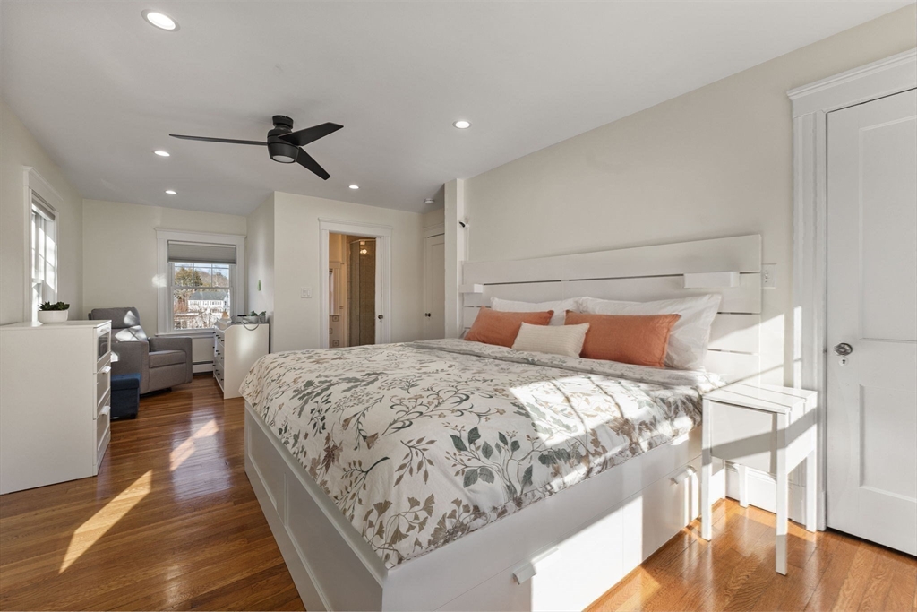 424 Brook Road Milton, MA 02186 - Photo 15 of 41 a spacious bedroom with a bed a couch and a chandelier