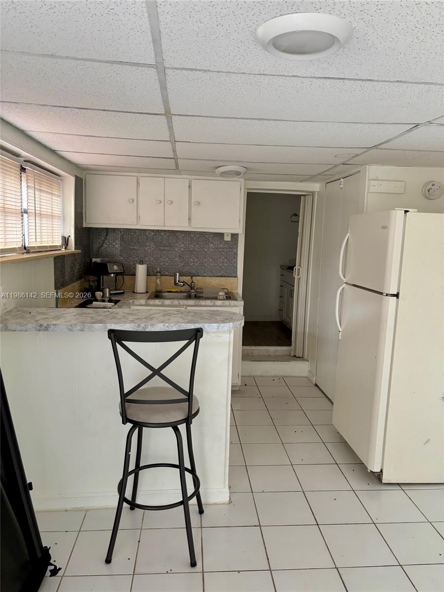 3241 Arthur Terrace Hollywood, FL 33021 - Photo 16 of 22 a kitchen with a sink a refrigerator and cabinets