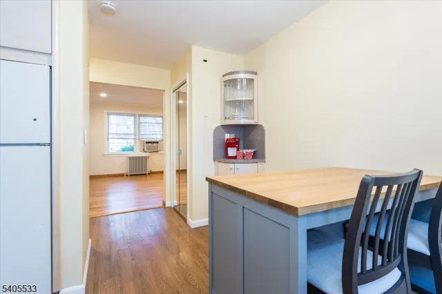 a view of a hallway to an empty room and wooden floor