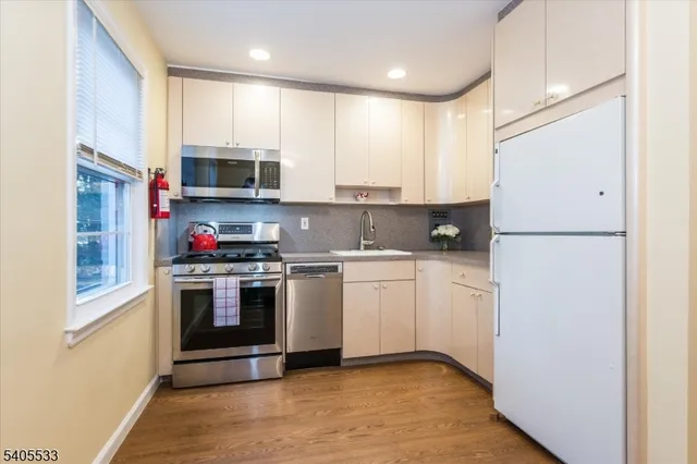 a kitchen with stainless steel appliances granite countertop a refrigerator sink and stove