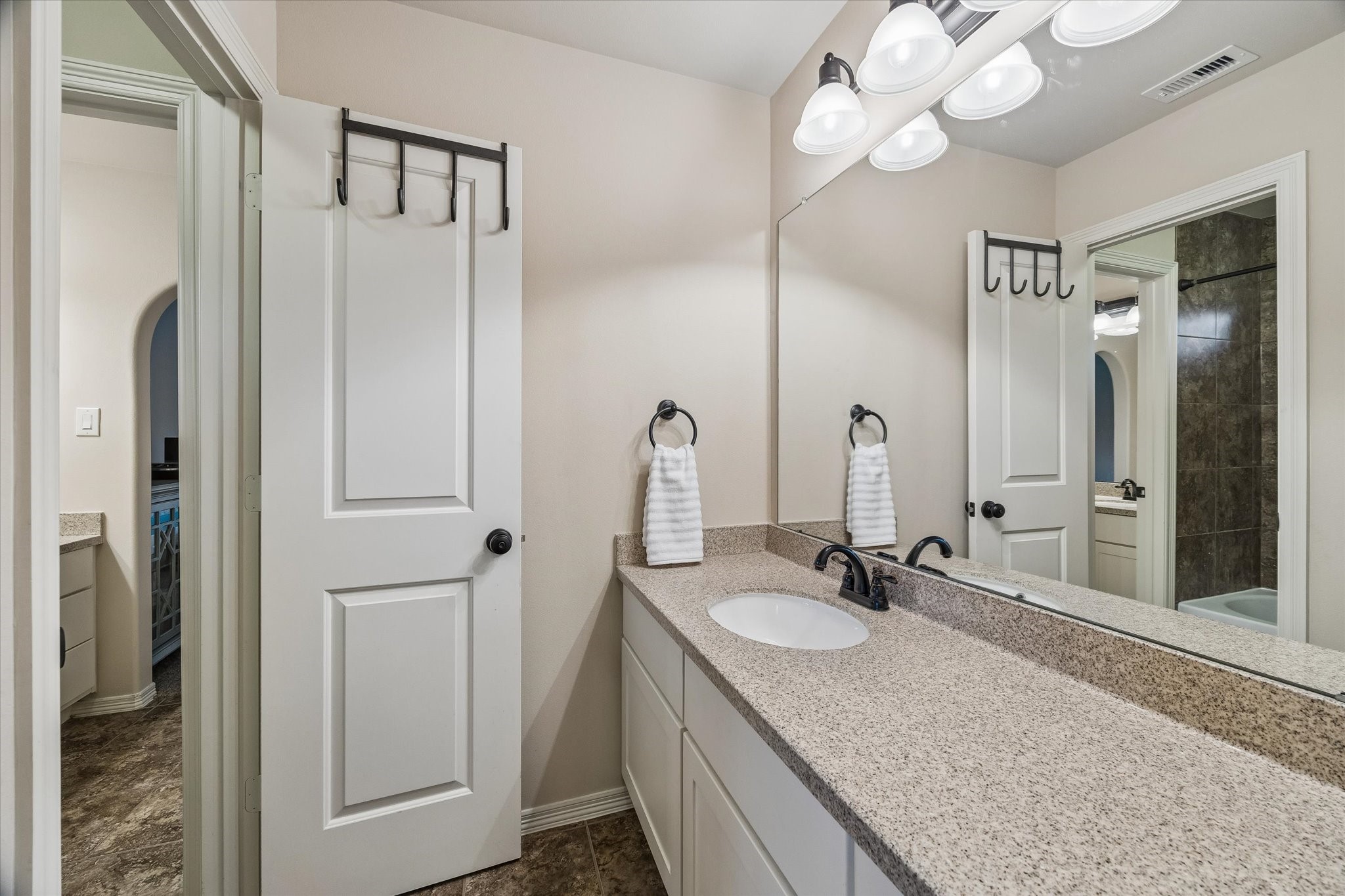 3 Tiburon Court Spring, TX 77389 - Photo 27 of 34 Designed with both privacy and practicality in mind, the Jack-and-Jill bath creates the perfect balance for busy households. Each adjoining bedroom enjoys its own private vanity and sink, allowing everyone to get ready at the same time without feeling crowded. The shared tub and shower are thoughtfully tucked between the spaces, making morning routines and bedtime rituals smooth and efficient.