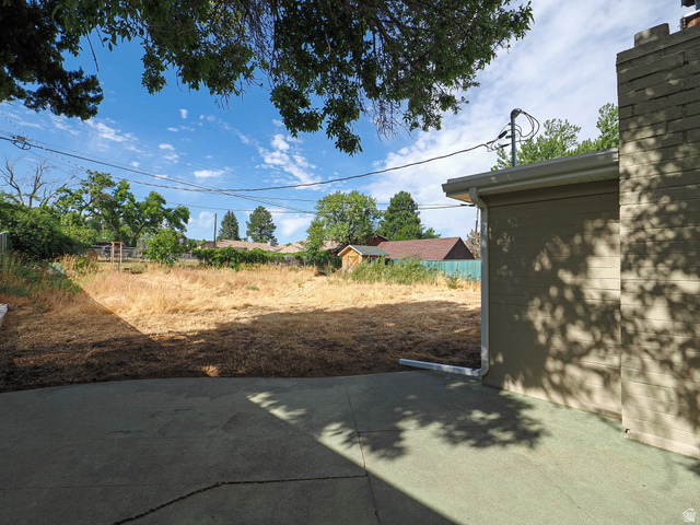 154 East 3000th Street South Bountiful, UT 84010 - Photo 36 of 37 Expansive outdoor space featuring a concrete patio, a large grass area, and mature perimeter trees