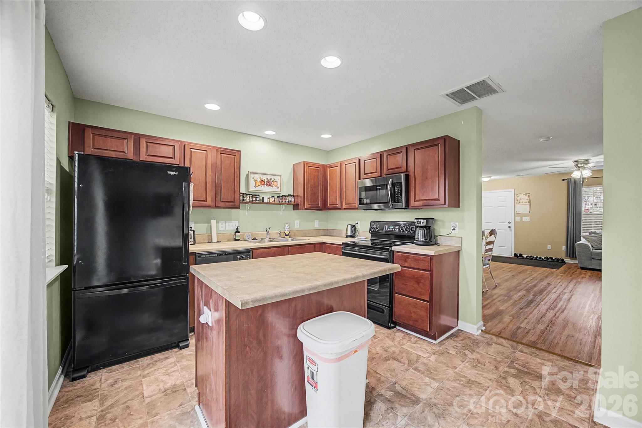 232 Butler Place Fort Mill, SC 29715 - Photo 11 of 32 a kitchen with a refrigerator a stove top oven a sink and a island