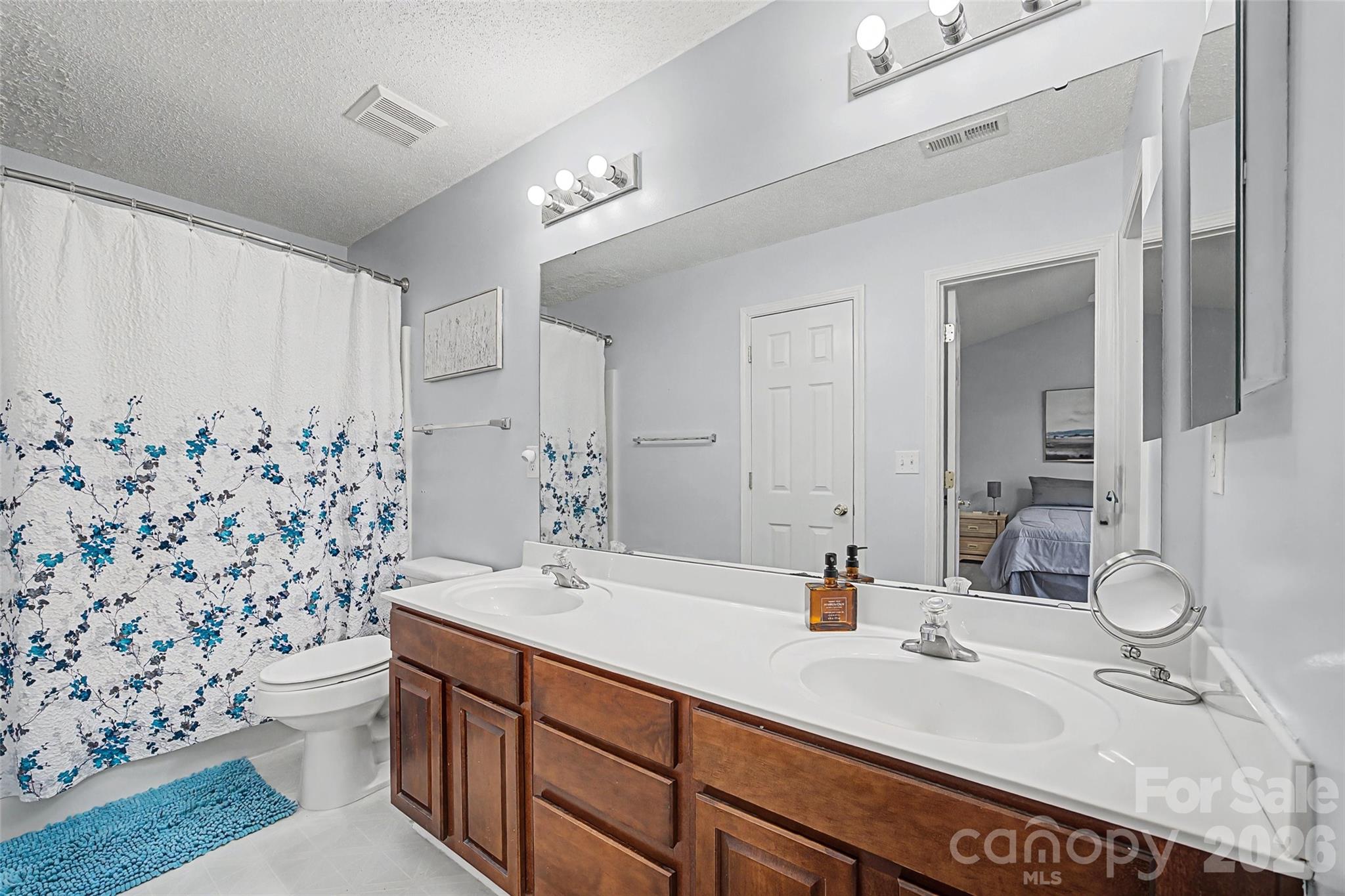 232 Butler Place Fort Mill, SC 29715 - Photo 17 of 32 a bathroom with double vanity sink toilet and shower