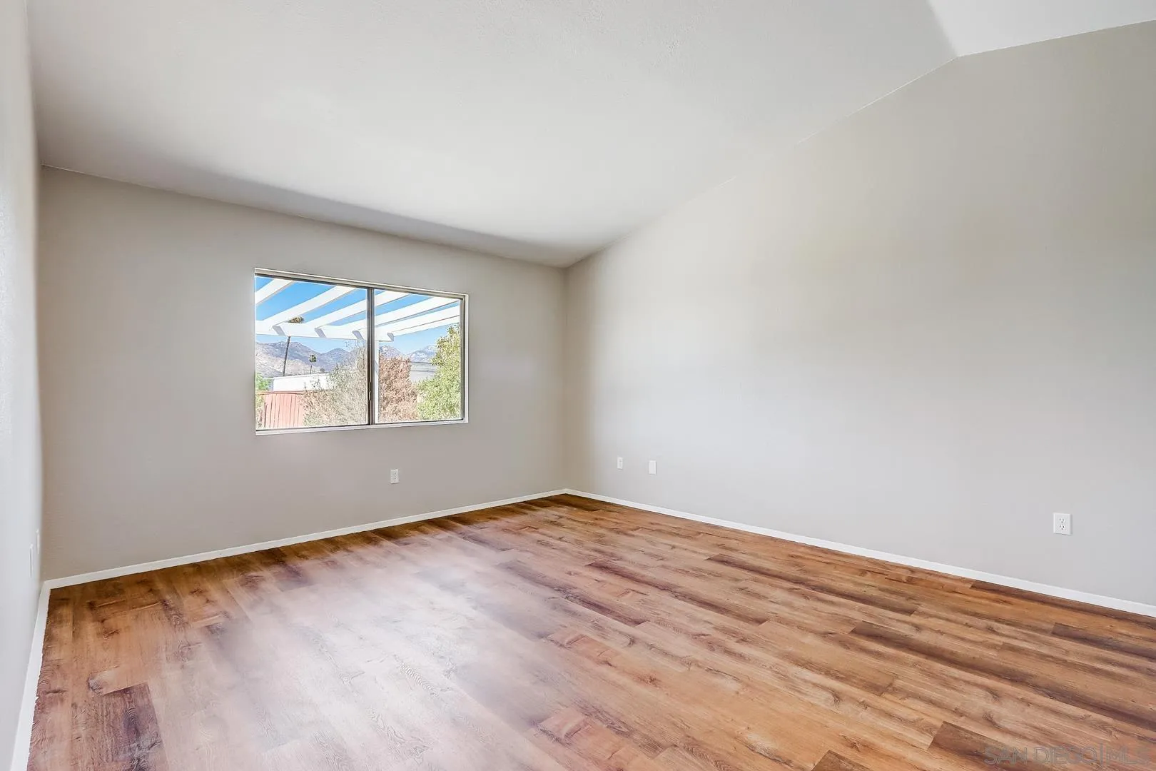 11988 Mountainview Heights Lakeside, CA 92040 - Photo 17 of 26 an empty room with wooden floor and windows