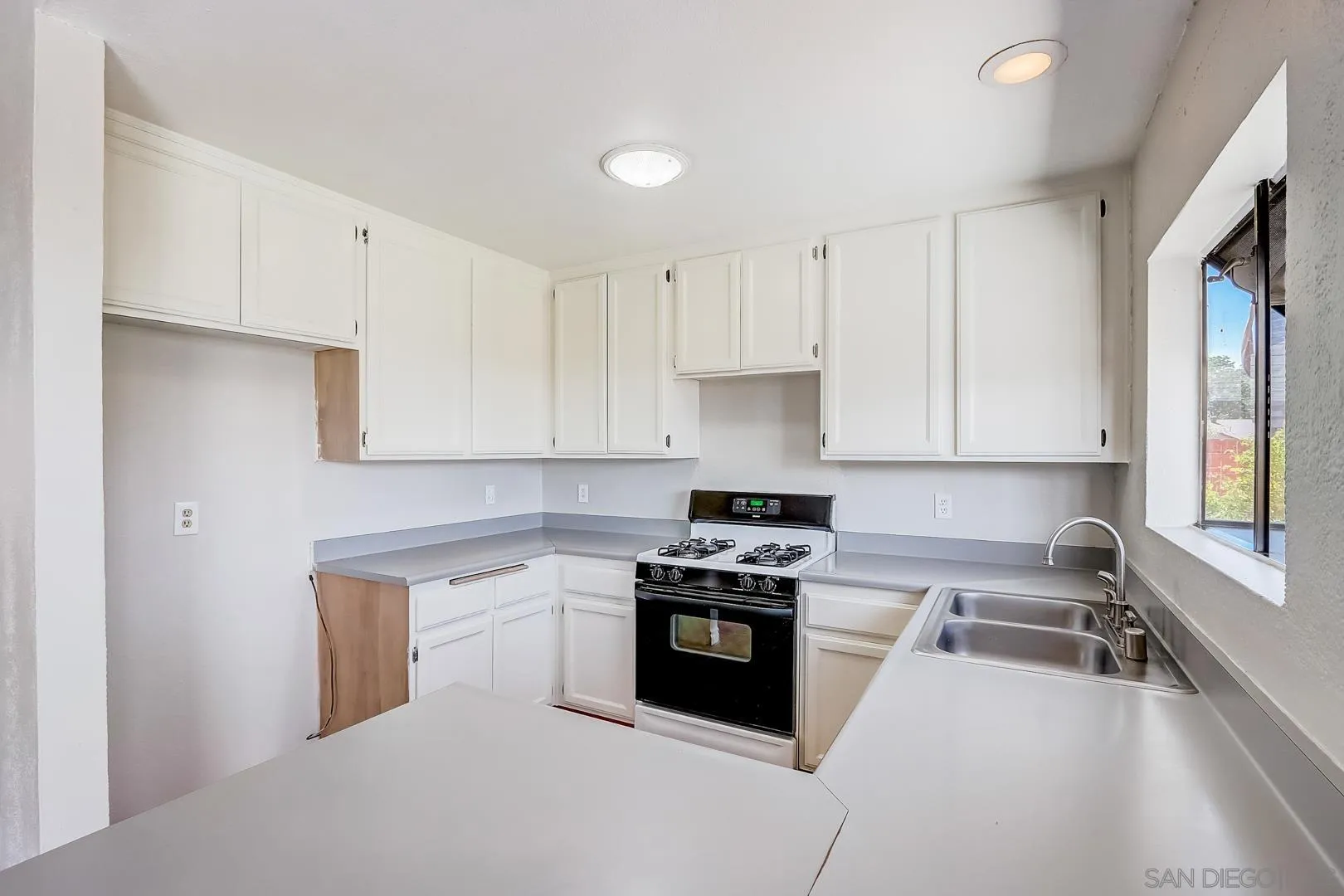 11988 Mountainview Heights Lakeside, CA 92040 - Photo 18 of 26 a kitchen with a sink a stove and cabinets